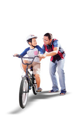 Father teaching his son to ride a bicycle on studio