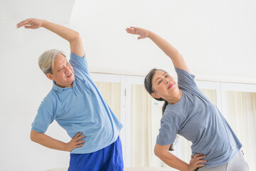 Senior couple exercising together in living room