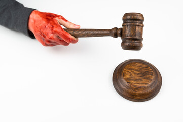 Female judge with bloody hands beats the gavel on a white background.