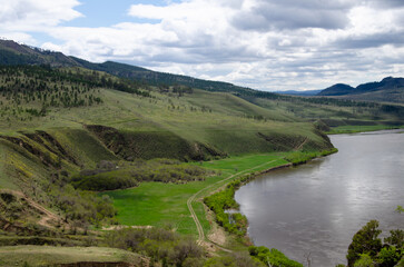 View of the bay of the river with steep banks covered with green grass.