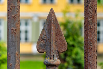Rusty wrought iron fence for private house with pointy arrow shape