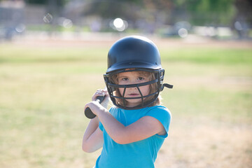 Fototapeta na wymiar Little child baseball player focused ready to bat. Sporty kid players in helmet and baseball bat in action.