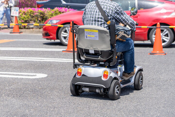 電動のシニアカーに乗る人