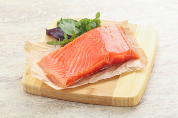 Raw salmon fillet over board