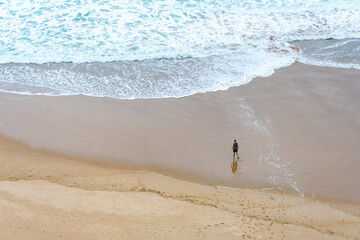 Lonely man walking to the sea in a beautiful shore - Contemplative mind