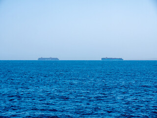 Two large cargo ships carrying containers by sea.