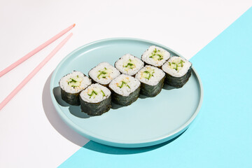 Classic japanese sushi with fresh cucumber - kappa maki. Kappa hosomaki in minimal style. Simple maki sushi with cucumber. Vegan sushi roll.