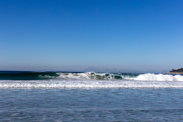 A view on ocean with white waves and blue sky