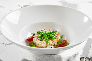 Original russian potato salad with green peas and mayonnaise. Russian christmas menu. Olivier salad with boiled potatoes, carrots, eggs, peas and meat with mayo dressing.  Traditional New year dish.