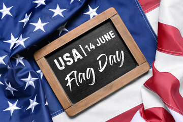 Fototapeta na wymiar Chalkboard with text 14 JUNE, FLAG DAY on American flag, top view
