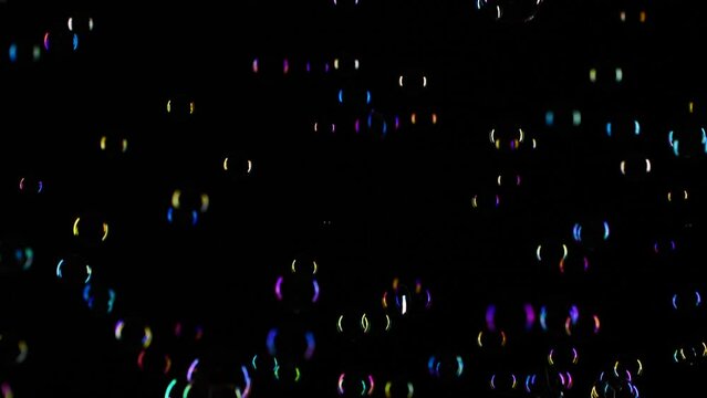 Slow motion of soap water bubbles texture flying over black abstract background