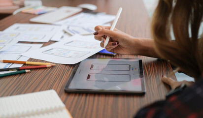 Female website designer working on digital tablet for sketch planning application process...