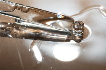 A pipette of cosmetic gel on a beige background.