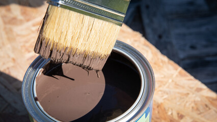 Paintbrush in the can of brown paint