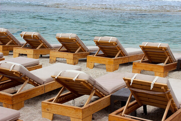 Beach lounge chairs empty with sea