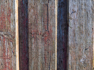 An old wall of planks laid vertically. Wooden natural background exposed to atmospheric influences with age. Wooden textured background