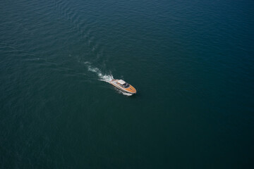Aerial view luxury motor yacht. Yachts at the sea surface. Travel - image. High-speed yacht of white color  on blue water in the rays of the sun top view.