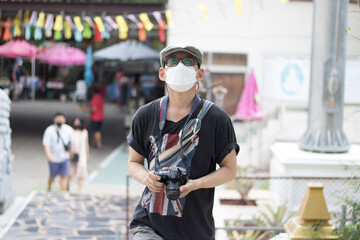 one person on tourist attraction and looking at wide holding a camera ready to take a photo,wearing a mask new normal and social distancting concept.