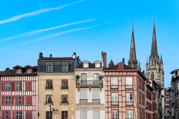 Fototapeta premium Bayonne in the pays Basque, typical facades with colorful shutters in the historic center, with the cathedral Sainte-Marie in background 