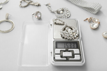 Jewelry scales with earrings on light background