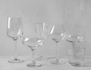 Stylish empty glasses on grey background