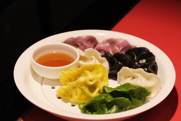 close up colorful Chinese dumplings on table with black copy space. Dumplings with stuffing and color