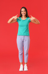 Pretty young woman in stylish t-shirt on red background