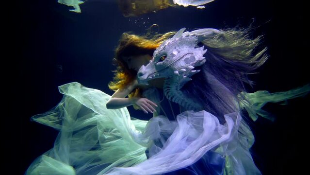 dragon and princess are swimming underwater in mysterious depth of magical sea or lake