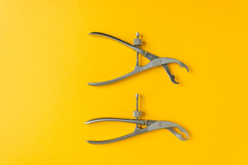 Two Verbrugge bone holding forceps isolated on the yellow background. To hold parts of the bone during surgery.