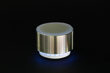 Glowing wireless portable speaker on dark background
