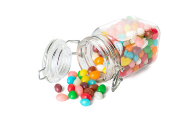 Glass jar with multicolored jelly beans on white background