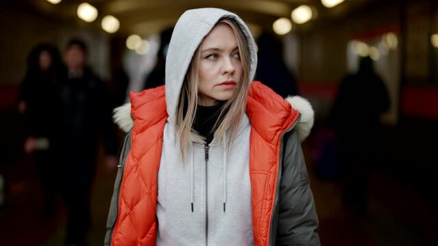 lost and tired by megapolis woman is standing in entrance of metro, portrait shot outdoors