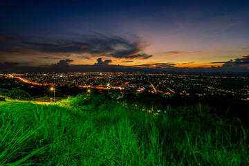 Obraz premium The high angle background of the city view with the secret light of the evening, blurring of night lights, showing the distribution of condominiums, dense homes in the capital community