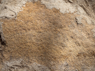 Close-up of sand-colored stone tiles on the wall. Abstract natural stone stone texture background for design. A stone wall. Brown stones. A wall with grey seams- Background. Rough, cold  stone