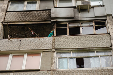 Fototapeta na wymiar Ukrainian-Russian War 2022. A residential building in Mykolaiv that suffered from Russian army shelling. The balcony of an apartment building without glass. A burned apartment building.