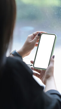 Back View Young Woman Holing Mobile Phone With White Screen For Graphics Display Montage.