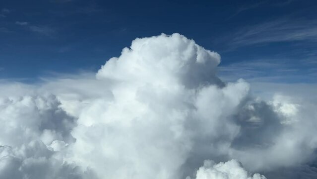 Aerial view taken from a jet cockpit of the top of a cumulonimbus at cruise level, daylight