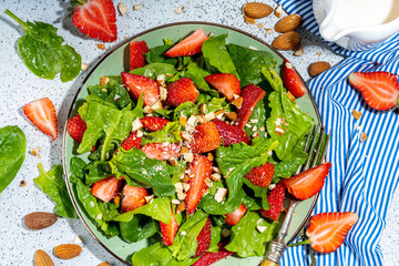 Strawberry, spinach and nuts salad. Healthy diet spring summer salad with farm spinach leaves, chopped almond and organic strawberry slices, copy space