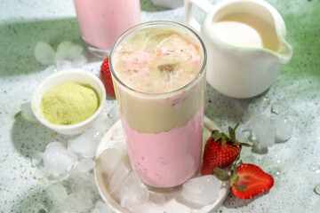 Natural healthy summer drink. Diet organic strawberry and matcha latte cocktail, with fresh strawberry and ice, on a white light green background