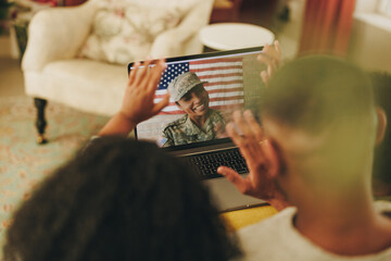 Happy female soldier video calling her family - obrazy, fototapety, plakaty