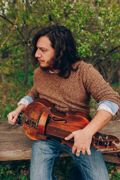 Musician with zanfona sitting on bench