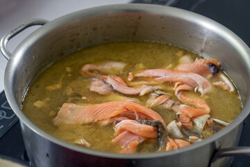 Base for a fish soup or sauce with carcasses, trimmings and skin cuttings is boiled down in vegetable broth and wine a large pot, copy space, selected focus, narrow depth of field