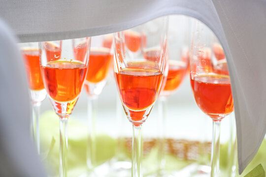 Spritz Veneziano with orange aperol prepared in champagne glasses covered with a napkin as an aperitif for a festive reception, selected focus
