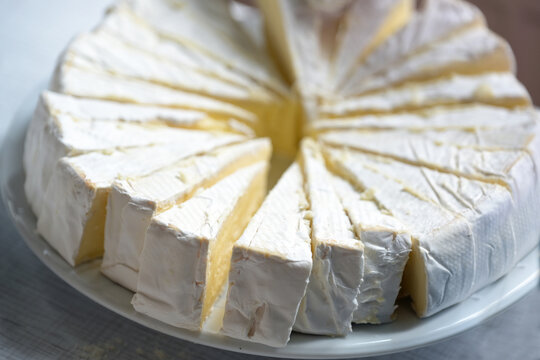 Large round camembert cheese cut into portions for a party buffet, copy space, selected focus