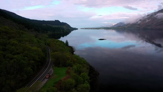 A Scotland Highland Bus Tour passing Loch Linnhe, Fort William on a calm Spring morning at sunrise