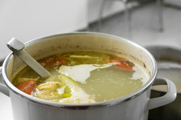 Broth from various vegetables is boiled down in a large pot, homemade cooking concept, copy space, selected focus