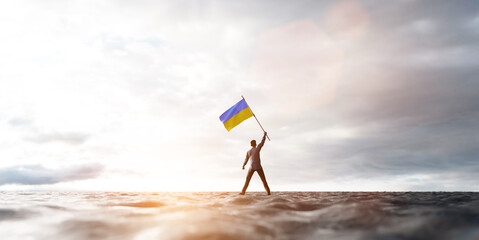 Man with Ukraine flag on abandoned wasteland.