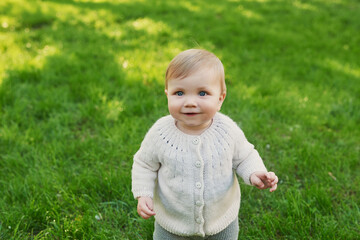 Smiling baby boy on grass in park. Children Protection Day. World Children's Day