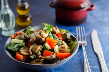 Summer meal a salad with himeji, oyster fungus, white Paris mushrooms mixed with young lettuce, tomatoes and cucumber.
