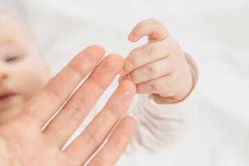 Ukrainian mother s hand holds newborn baby fingers, Close up. mothers Day. emotional bond between mother and child. The first days of a baby's life